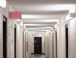 Corridor of student dorm with an illuminated Exit sign