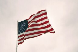 An American flag atop a flagpole waves in the wind.