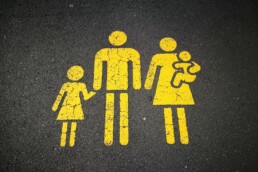 Family figures painted in yellow on pavement