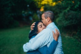 Couple embraces each other in a hug outside in their backyard