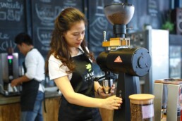 Female cafe worker makes a beverage