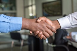 Two men shake hands in a business setting