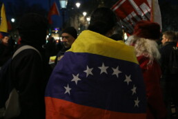 Person stands in a crowd wearing the Venezuelan flag around their body