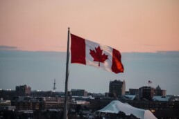 Canadian flag flying over city skyline