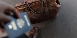 Man with duffel bag holding passport